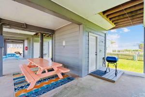 a patio with a picnic table and a grill at Sandy Beach Retreat and Gulf View in Galveston