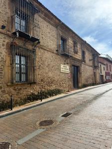 an empty street in front of a brick building at La Casuca in Riaza