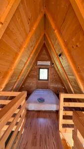 a bedroom in a wooden attic with a bed in it at Nota A Frame in Šakotinac