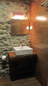 a bathroom with a sink and a stone wall at Apartaments Major in Barruera