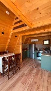 a kitchen with a wooden ceiling with a table and chairs at Nota A Frame in Šakotinac +14 photos