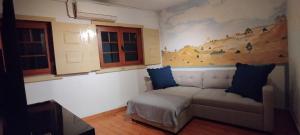 a living room with a couch and a painting on the wall at Casa Rústica da Lavandeira in Valongo dos Azeites