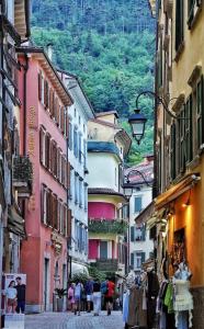 a group of people walking down a street with buildings at Vecchia Riva in Riva del Garda