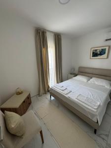 a bedroom with a large bed and a window at MostOliva luxury Rooms in Pržno