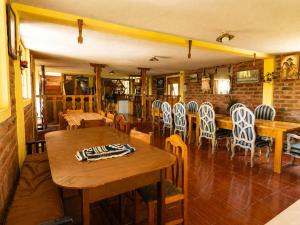 a dining room with wooden tables and chairs at Hostal el Vaquero in Chugchilán +94 photos