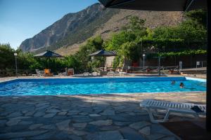 a swimming pool with a mountain in the background at Bungalow - Camping Apollon in Delphi