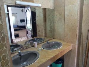 a bathroom with three sinks in front of a mirror at Villa pieds dans l'eau Cabo in Cabo Negro +16 photos