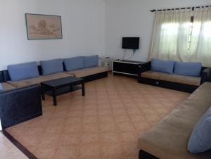 a living room with couches and a flat screen tv at Villa pieds dans l'eau Cabo in Cabo Negro