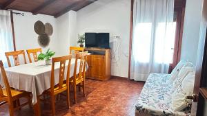a dining room with a table and a tv at Apartamento Tres in Guadalaviar