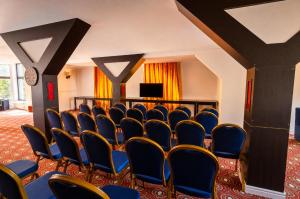 a conference room with blue chairs and a flat screen tv at Hotel Baia Rosie Resort in Slănic +96 photos