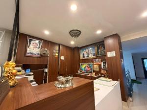 a room with a wooden table and some pictures at Hotel A3cube in Panna