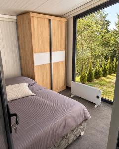 a bedroom with a bed and a large window at Oaza mira Zlatibor, Tornik - ENTIRE HOME at Ski Centar Tornik in Tornik