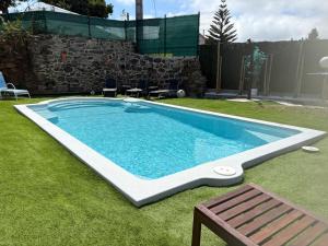 a swimming pool in a yard with a bench at Casa con piscina in Cedeira