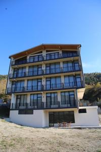 a building with two chairs in front of it at Mn Hotel Borjomi in Borjomi