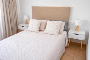 a bedroom with a large bed with two night stands at Formentera Suite 3 in Es Pujols