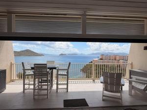 a balcony with a table and chairs and a view of the ocean at Mermaid Escape - Amazing Views! in East End
