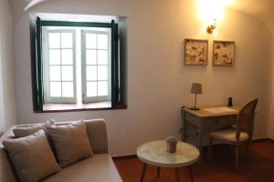 a living room with a couch and a table and a desk at SOLAR DOS FRADES in Ferreira do Alentejo