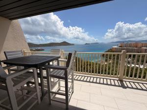a table and chairs on a balcony with a view of the ocean at Mermaid Escape - Amazing Views! in East End