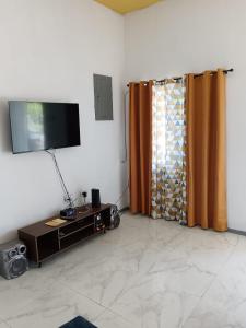 a living room with a television and a curtain at 25 Spice in Port Antonio