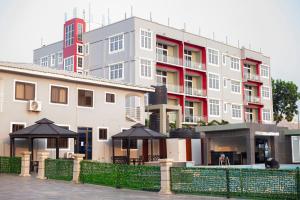 a large building with black umbrellas in front of it at Adonai Hotel & Apartment in Spintex