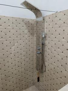 a shower in a bathroom with white tiled walls at 25 Spice in Port Antonio +14 photos