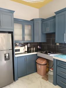 a kitchen with blue cabinets and a white refrigerator at 25 Spice in Port Antonio