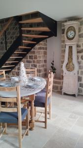 a dining room with a table and a clock at Gîte La Ferme Ecole in Perrou