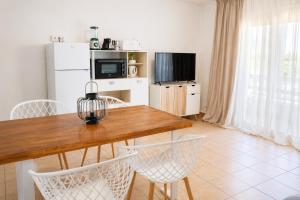 a kitchen with a table and chairs and a television at Formentera Suite 3 in Es Pujols