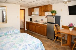 a kitchen with a bed and a table and a refrigerator at Neptune Motel Maine in Old Orchard Beach