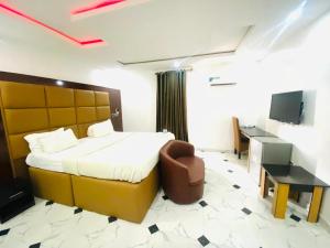 a bedroom with a bed and a chair and a desk at Wiztk suites in Sangotedo