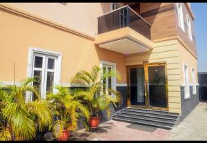 a house with palm trees in front of it at Wiztk suites in Sangotedo +9 photos
