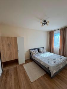 a bedroom with a bed and a ceiling fan at Casuta Vacanta Sadu in Cisnădie