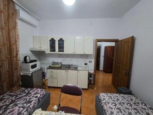 a room with a kitchen with a bed and a table at Evelin Apartment Berat in Berat