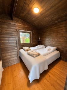 two beds in a room with wooden walls at Hotel Stadarborg in Breiðdalsvík