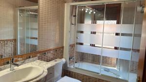 a bathroom with a sink and a glass shower at Apartamento Uno in Guadalaviar