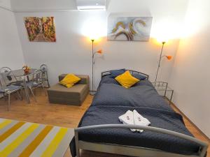 a bedroom with a bed and a table and chairs at Prestige apartman in Miskolc