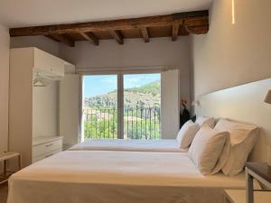 a bedroom with a large bed with a large window at Mirador Del Rey in Cuenca