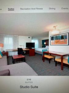 a hotel room with a bed and a living room at Residence Inn in Maumee