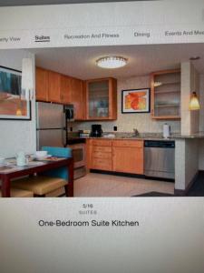 a kitchen with wooden cabinets and a table in it at Residence Inn in Maumee