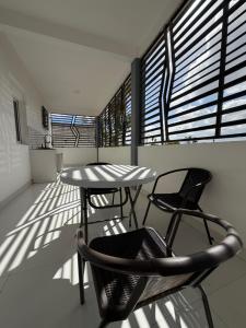 a balcony with two chairs and a table and a window at C-Appart Residence in Tuléar