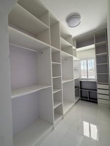 a white walk in closet with white shelves at C-Appart Residence in Tuléar