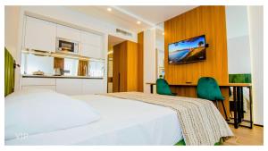 a bedroom with a bed and a tv on a wall at VIP In Alliance Palace in Batumi