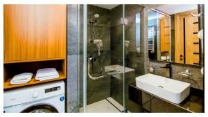 a bathroom with a shower and a sink and a washing machine at VIP In Alliance Palace in Batumi +30 photos
