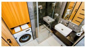 a bathroom with a sink and a washing machine at VIP In Alliance Palace in Batumi