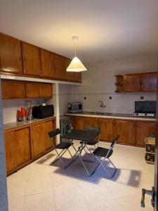 a kitchen with wooden cabinets and a table and chairs at Étoile in M'diq