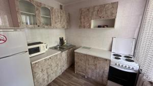 a small kitchen with a white refrigerator and a sink at Nice Apartment in Kyiv +12 photos
