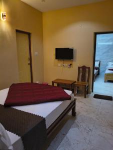 a bedroom with a bed and a flat screen tv at Kodai Cloud Villa in Kodaikānāl