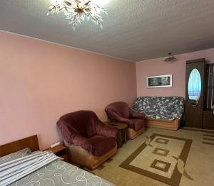 a living room with two chairs and a bed at Nice Apartment in Kyiv