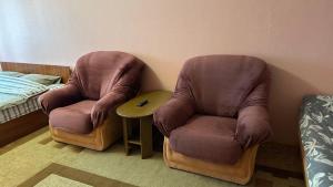 two chairs sitting in a room next to a bed at Nice Apartment in Kyiv