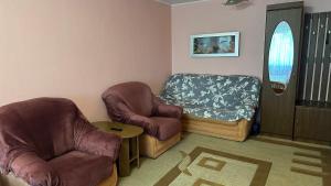 a living room with two chairs and a window at Nice Apartment in Kyiv